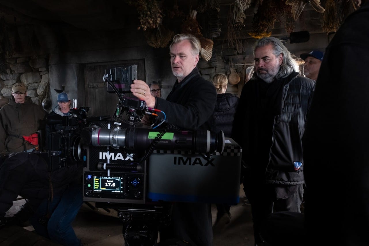 크리스토퍼 놀란 감독이 '오디세이' 촬영 현장에서 IMAX 카메라를 점검하고 있다